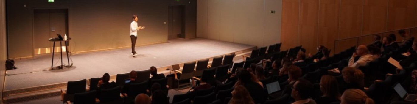 Juan holder oplæg foran et fuldt auditorium